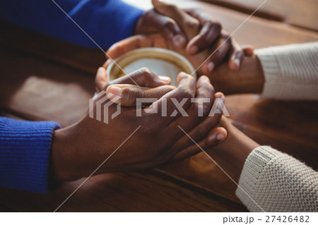 Couple holding hands while having coffee 27426482