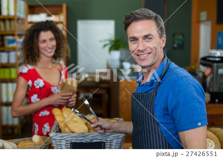 Portrait of male staff standing at bakery store counter 27426551