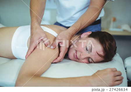 Physiotherapist giving shoulder massage to a woman 27426634