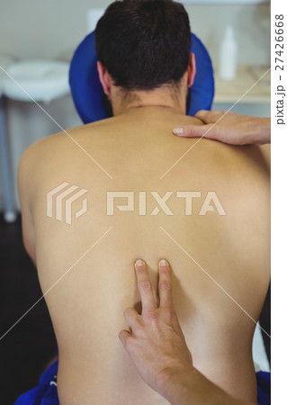 Physiotherapist giving back massage to a patient 27426668