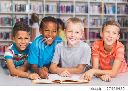 School kids reading book together in library 27426983