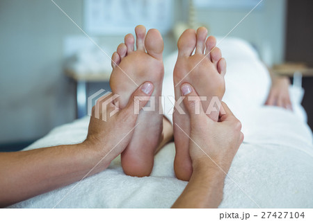 Physiotherapist giving foot massage to a woman 27427104