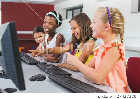 Schoolgirls using computer in classroom Schoolgirls using computer in classroom 27427379