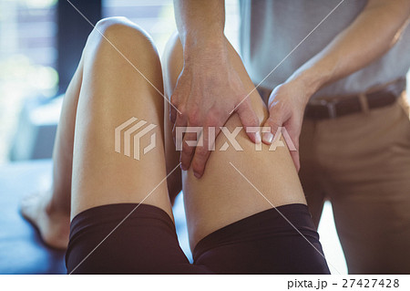 Physiotherapist giving leg massage to a woman Physiotherapist giving leg massage to a woman 27427428