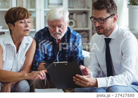 Senior couple planning their investments with financial advisor Senior couple planning their investments with financial advisor 27427880