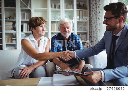Financial advisor shaking hands with senior woman Financial advisor shaking hands with senior woman 27428052