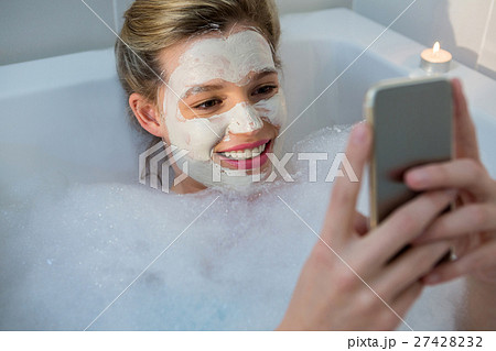 Woman using mobile phone while having bath in bathtub 27428232