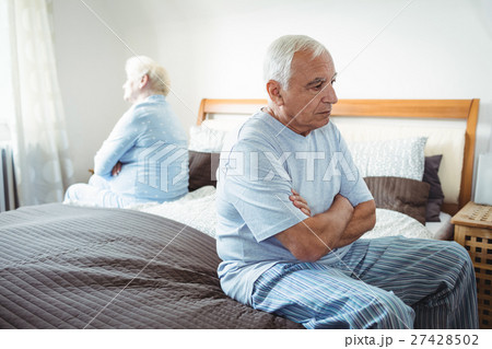 Sad senior couple sitting on bed Sad senior couple sitting on bed 27428502