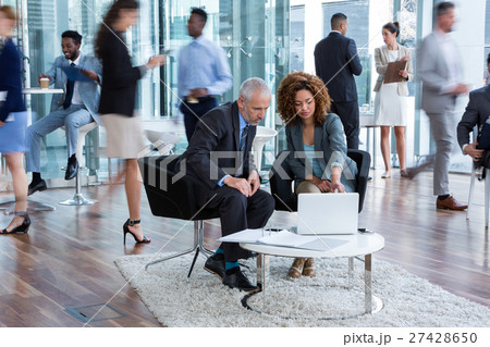 Businesspeople discussing over laptop 27428650