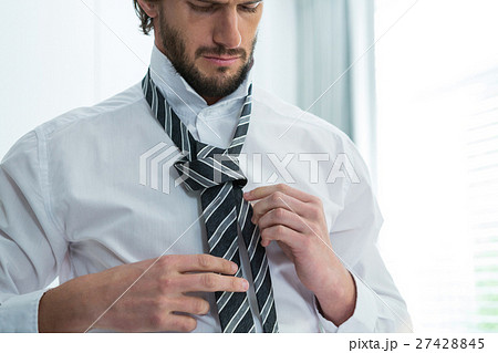 Man getting dressed in bedroom 27428845