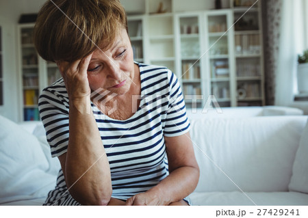Tense woman sitting on sofa in living room 27429241