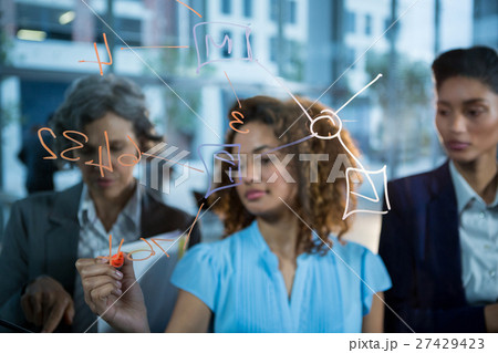 Businesswoman writing with marker on glass 27429423