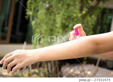 Woman spraying insect repellents on her arm 27431474