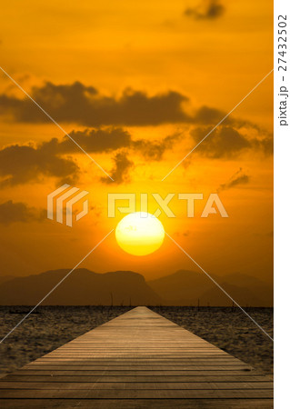 empty wooden floor into the lake with sunset 27432502