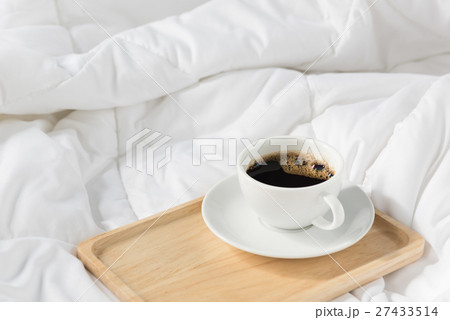 Cup of coffee with wooden tray on bed background 27433514