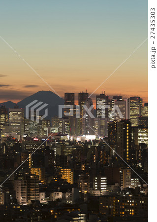 東京都市風景 夕暮れ黄昏 富士山と新宿高層ビル群 夕焼け 街明かりの写真素材