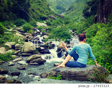 Woman doing Ardha matsyendrasana asana outdoors Woman doing Ardha matsyendrasana asana outdoors 27435323
