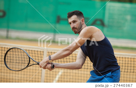 Happy young man playing on tennis clay court. 27440367