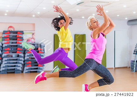 Two fitness models exercising in gym, dancing Two fitness models exercising in gym, dancing 27441922