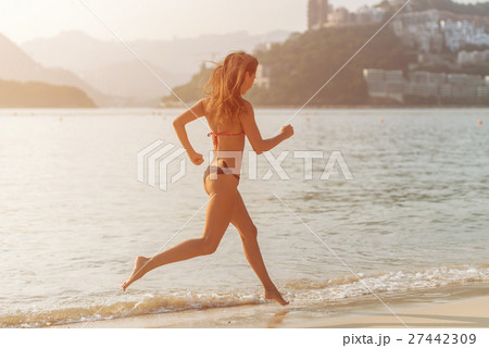 Back view of fit slim girl running barefoot on 27442309