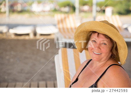 Smiling Senior woman wearing hat at beach on 27442593