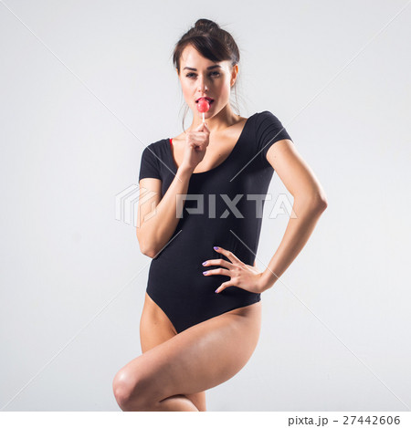 Young brunette model with lollipop studio shot on 27442606