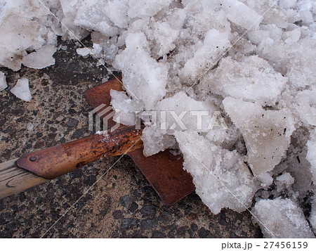 スコップで道路の氷を砕く作業の写真素材