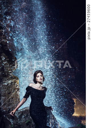 Woman posing near waterfall. 27459600