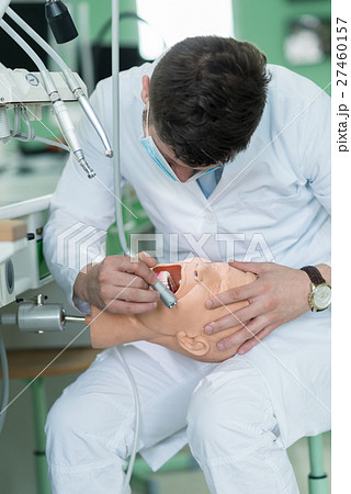 Male dental student practicing on doll. 27460157