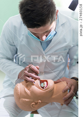 Male dental student practicing on doll. 27460158