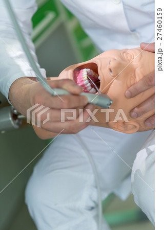 Male dental student practicing on doll. 27460159