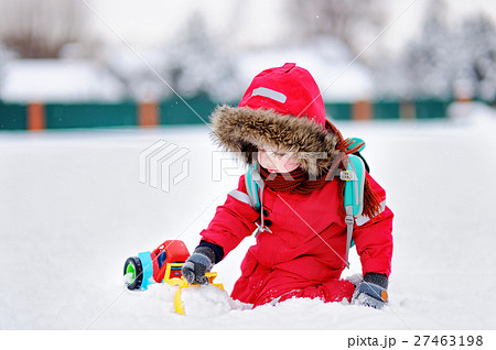 Little boy playing with bright car toy and fresh snow Little boy playing with bright car toy and fresh snow 27463198
