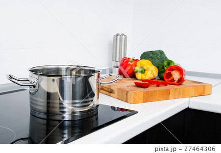 Pot and vegetables in kitchen with induction stove Pot and vegetables in kitchen with induction stove 27464306