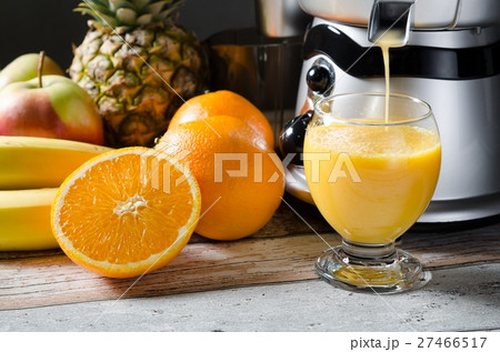 Fresh juice and juicer. Photo on wooden background 27466517