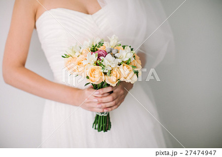 The bride holds a beautiful wedding bouquet in 27474947