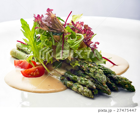 Grilled asparagus with tomatoes and arugula. 27475447