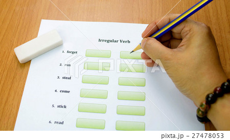 hand holding pencil over english exercise on table hand holding pencil over english exercise on table 27478053