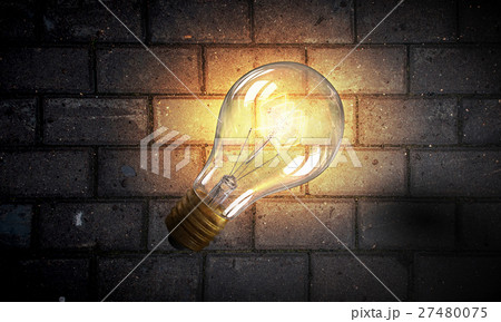 Light bulb on brick surface 27480075