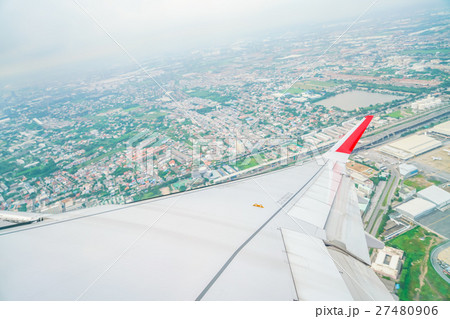 Wing of an airplane flying above the clouds . Wing of an airplane flying above the clouds . 27480906