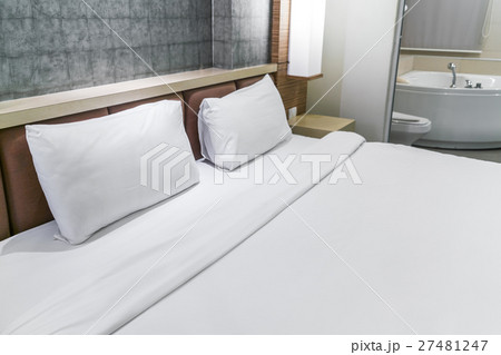 Comfortable pillows and bed . 27481247