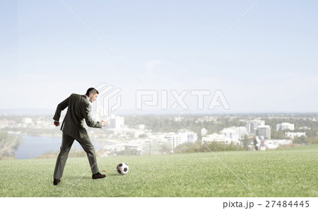Businessman kicking soccer ball 27484445