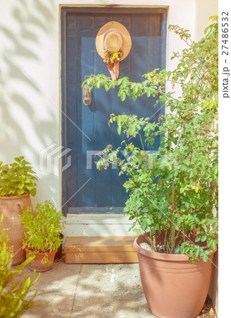 Old blue door with hat and flowers Old blue door with hat and flowers 27486532