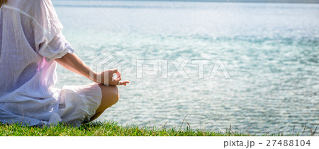 Woman meditating at the lake Woman meditating at the lake 27488104