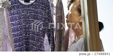 一人暮らし 高齢者 洗濯物を干す女性の写真素材