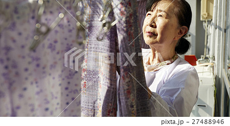 一人暮らし 高齢者 洗濯物を干す女性の写真素材