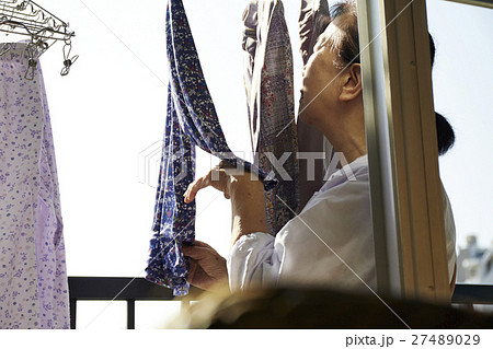 一人暮らし 高齢者 洗濯物を干す女性の写真素材