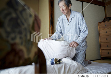 一人暮らしをする高齢者　寝具を畳む男性 27489064
