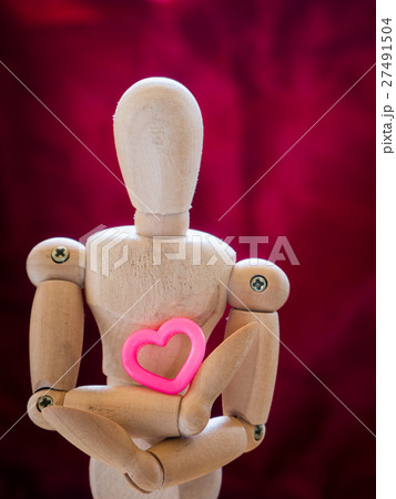 Still life wooden puppet and pink heart. Still life wooden puppet and pink heart. 27491504