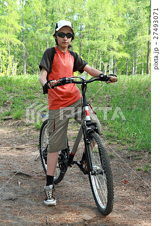 The teenager in a wood on a bicycle 27493071