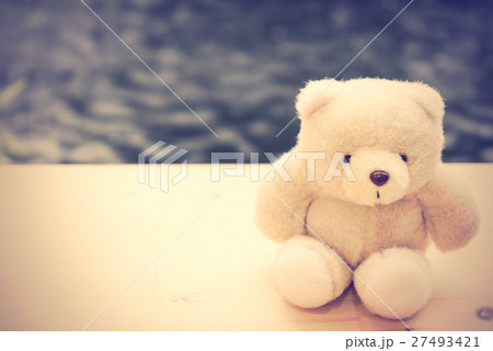 Cute teddy bear sit alone on wooden floor  27493421